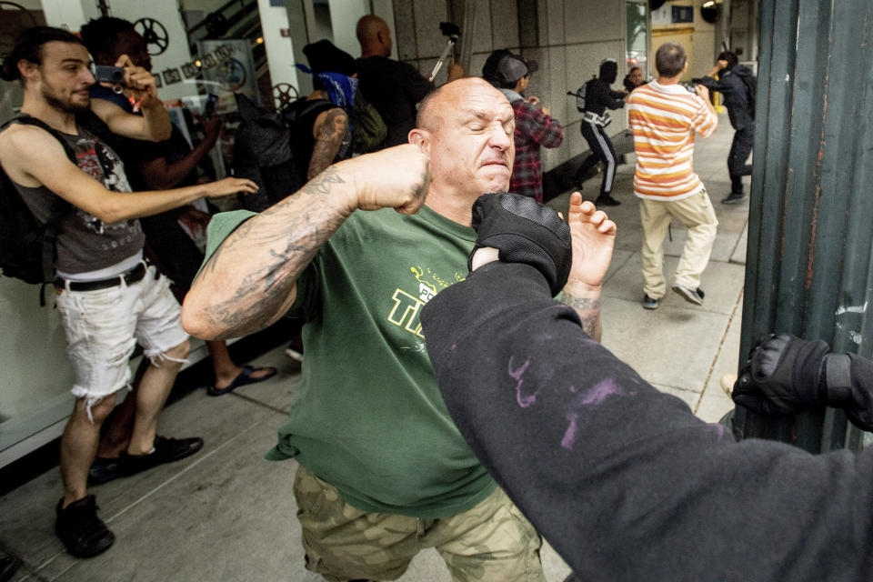 A man tussles with protesters against right-wing demonstrators following an "End Domestic Terrorism" rally in Portland, Ore., on Saturday, Aug. 17, 2019. Although the main protest remained largely peaceful, some skirmishes erupted in the following hours and police detained multiple protesters. (AP Photo/Noah Berger)