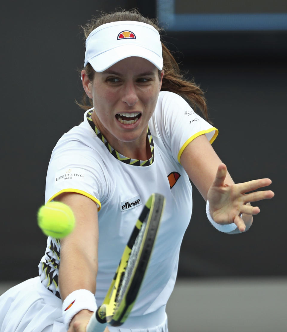 Johanna Konta of Britain makes a backhand return to Tunisia's Ons Jabeur during their first round singles match at the Australian Open tennis championship in Melbourne, Australia, Tuesday, Jan. 21, 2020. (AP Photo/Dita Alangkara)