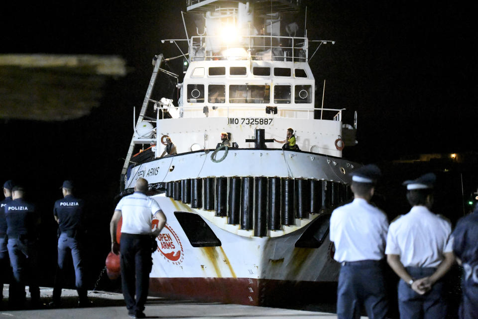 The Open Arms rescue ship arrives on the Sicilian island of Lampedusa, southern Italy, Tuesday, Aug. 20, 2019. Italian prosecutor Luigi Patronaggio has ordered the seizure of a migrant rescue ship and the immediate evacuation of more than 80 migrants remaining on board, capping dramatic developments that saw 15 migrants jump into the sea in a desperate bid to reach land and the Spanish government dispatch a Naval ship on a long journey to resolve the escalating crisis. (AP Photo/Salvatore Cavalli)