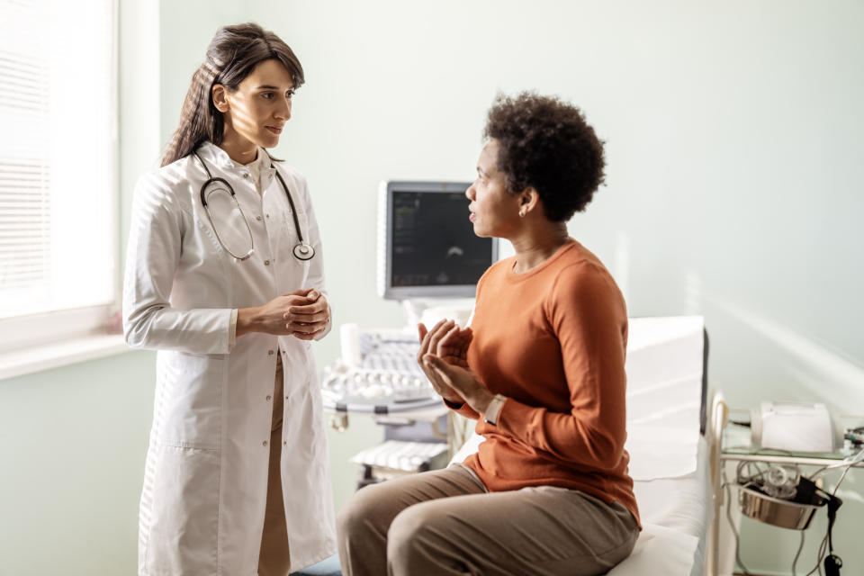 A female doctor talks with her patient sitting on a doctor's chair