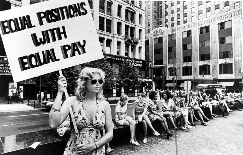 A lone woman stands on a corner protesting unequal pay for women in an unidentified section of Cincinnati, Ohio, circa 1970s.&amp;nbsp;