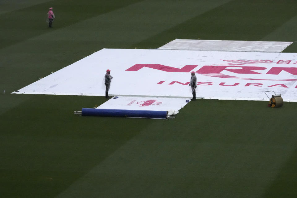 The covers are on the wicket as rain falls before play on the third day of the cricket test match between Australia and South Africa at the Sydney Cricket Ground in Sydney, Friday, Jan. 6, 2023. (AP Photo/Rick Rycroft)