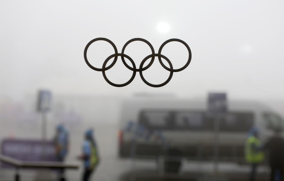 Olympic rings on a window are silhouetted against thick fog at the Laura Biathlon centre at the 2014 Winter Olympics, Monday, Feb. 17, 2014, in Krasnaya Polyana, Russia. The men’s 15-kilometer mass-start biathlon race at the Sochi Olympics has been delayed due to fog, one day after the event had been called off for the same reason. (AP Photo/Felipe Dana)