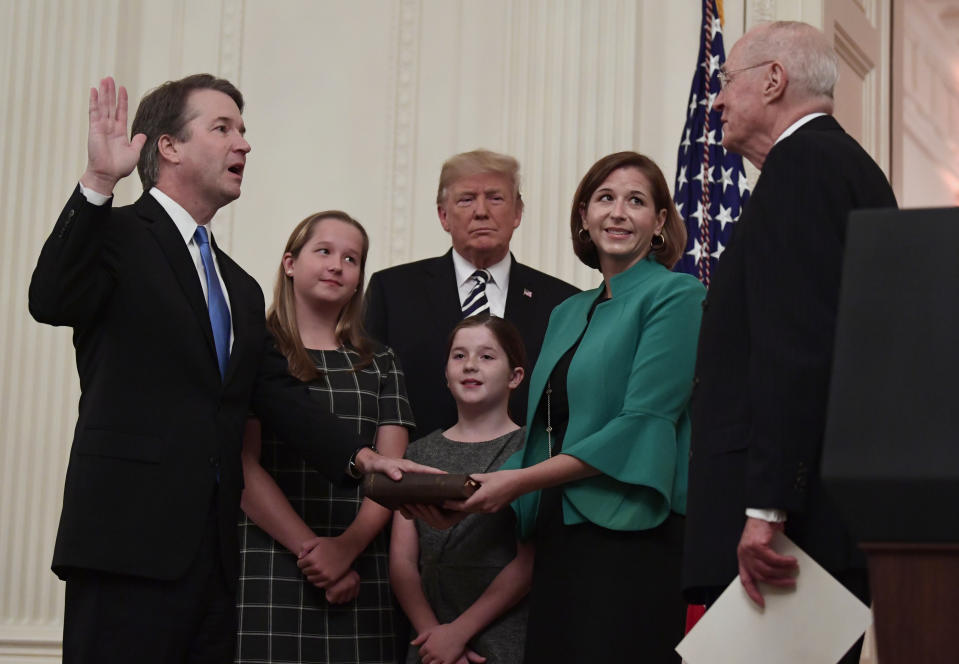 FILE - In this Oct. 8, 2018, file photo, President Donald Trump, center, listens as retired Supreme Court Justice Anthony Kennedy, right, ceremonially swears-in Supreme Court Justice Brett Kavanaugh, left, in the East Room of the White House in Washington. Kavanaugh's wife Ashley watches, second from right with daughters Margaret, left, and Liza. (AP Photo/Susan Walsh, File)