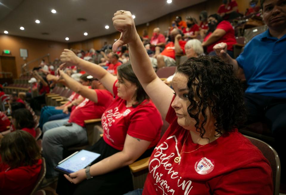 Kacie Franklin, a parent of kids in the Peoria Unified School District, and others in the gallery give a thumbs down as Republican House members speak during the House vote on bills related to the budget on June 24, 2021.