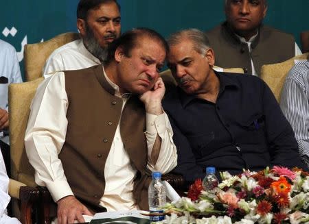 FILE PHOTO - Nawaz Sharif talks with his brother Shahbaz Sharif before addressing his party members who were voted to political posts in the general election, during a function in Lahore May 20, 2013. REUTERS/Mohsin Raza