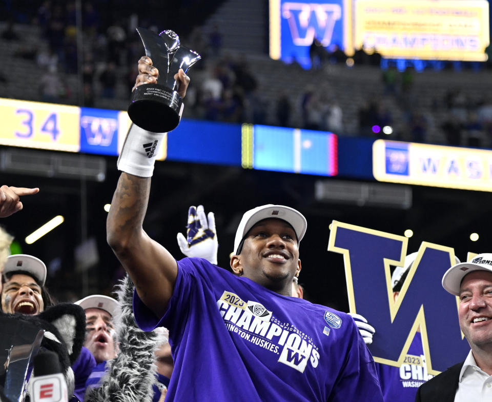 Washington quarterback Michael Penix Jr. celebrates with his MVP trophy after Washington defeated Oregon in the Pac-12 championship NCAA college football game Friday, Dec. 1, 2023, in Las Vegas. (AP Photo/David Becker)