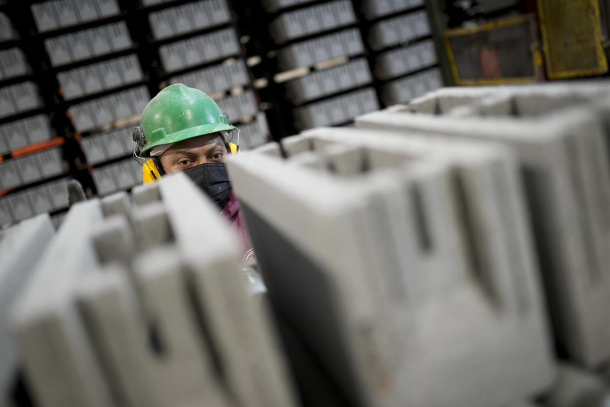 Workers monitor a production line of concrete blocks, made with liquid carbon dioxide as an ingredient, at the Glenwood Mason Supply Company, Tuesday, April 18, 2023, in the Brooklyn borough of New York. New York is forcing buildings to clean up, and several are experimenting with capturing carbon dioxide, cooling it into a liquid and mixing it into concrete where it turns into a mineral. (AP Photo/John Minchillo)