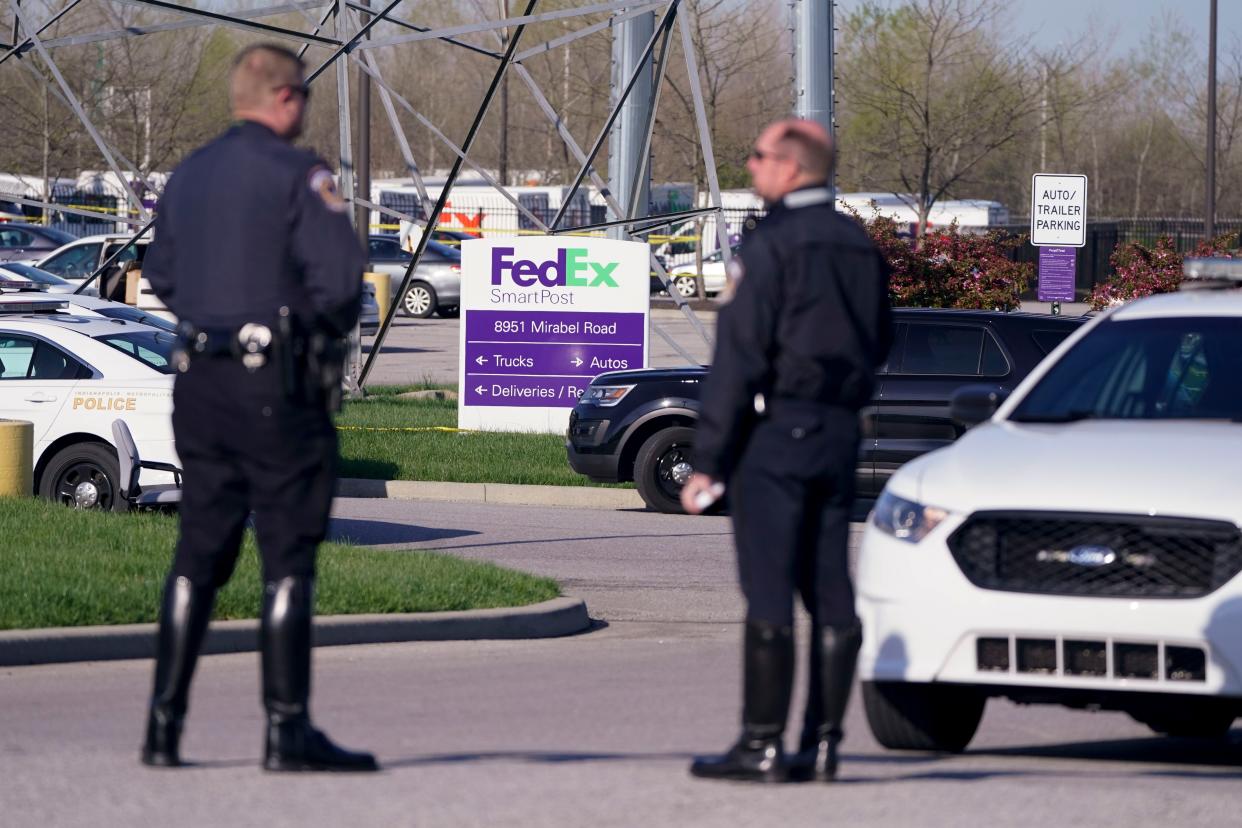 Police stand near the scene where multiple people were shot at the FedEx Ground facility early Friday morning, April 16, 2021, in Indianapolis. A gunman killed eight people and wounded several others before apparently taking his own life in a late-night attack at a FedEx facility near the Indianapolis airport, police said.