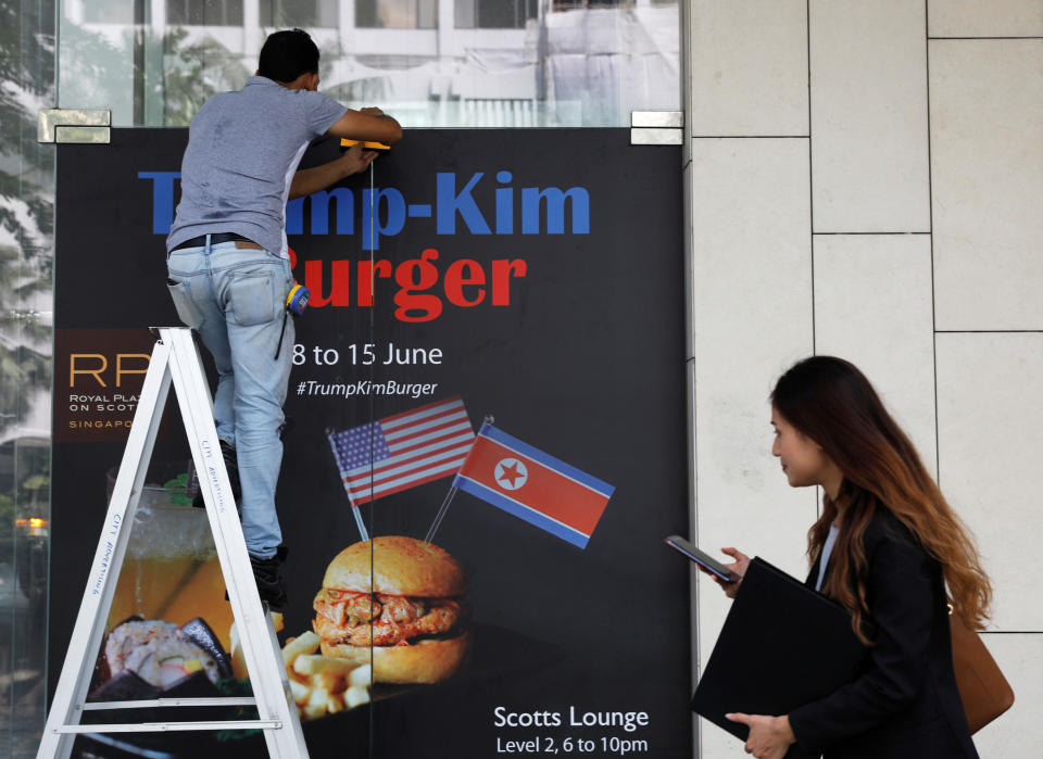 A worker puts up an advertisement for the Trump-Kim burger, at Royal Plaza on Scotts hotel in Singapore. (Photo:REUTERS/Edgar Su)