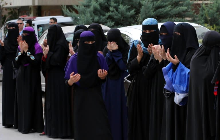 Uighur women pray during a demonstration outside the Chinese embassy in Ankara, on July 9, 2015