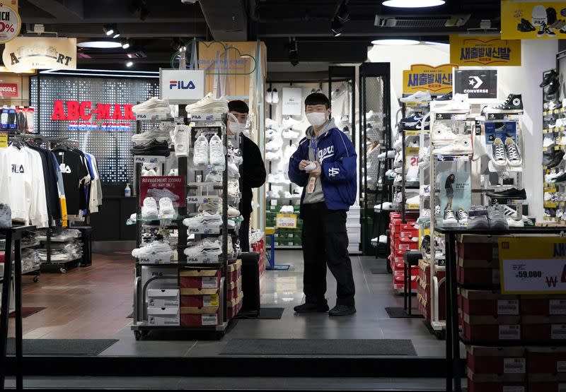 Shopkeepers wearing masks to prevent contracting the coronavirus wait for a customer at Dongseong-ro shopping street in central Daegu