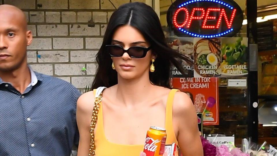 The supermodel looked glamorous at a low-key corner store while picking up a Coca-Cola that coincidentally matched her dress.