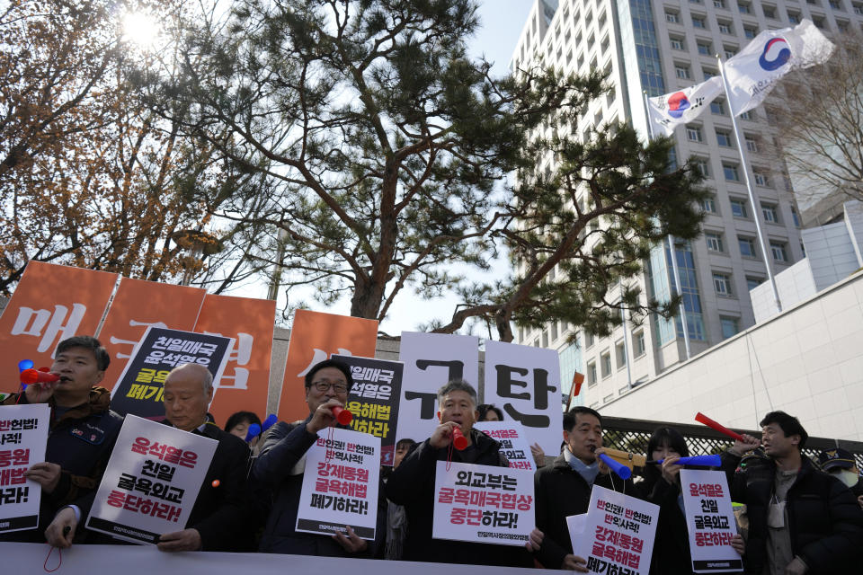 Members of civic groups blow horns during a rally against the South Korean government's announcement of a plan over the issue of compensation for forced labors, in front of the Foreign Ministry in Seoul, South Korea, Monday, March 6, 2023. South Korea on Monday announced a contentious plan to raise local civilian funds to compensate Koreans who won damages in lawsuits against Japanese companies that enslaved them during Tokyo's 35-year colonial rule of the Korean Peninsula. Banners read "Discards humiliating solution to forced labor issue." (AP Photo/Lee Jin-man)