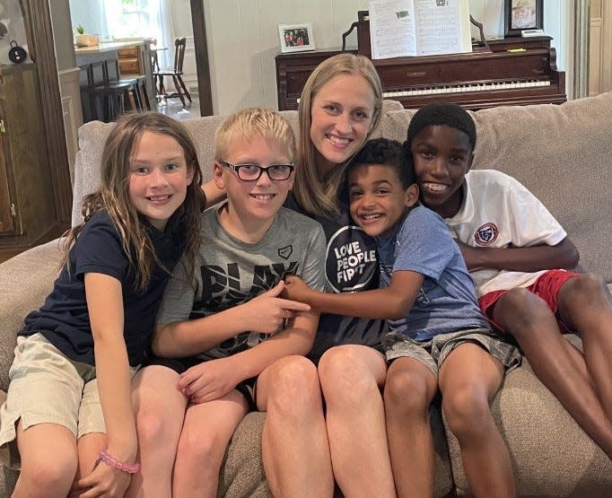 Mandy Marburger huddles up with her four children, Scarlette, Beckett, Isaiah, and Sirrvonte. She and her husband also foster a daughter who was not able to be photographed.