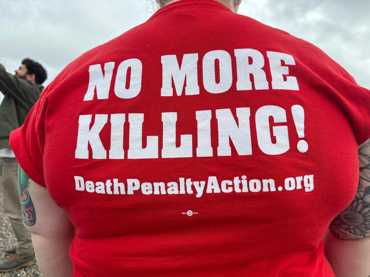Anti-death penalty activists place signs along the road heading to Holman Correctional Facility (AP)