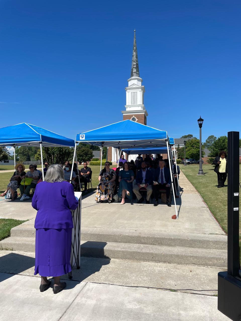 Paine College President Dr. Cheryl Evans Jones addresses guests Thursday, May 2, in dedicating a state historical marker honoring John Wesley Gilbert, the first acknowledged Black archaeologist. Paine's Gilbert-Lambuth Chapel, sharing his name, stands in the background.