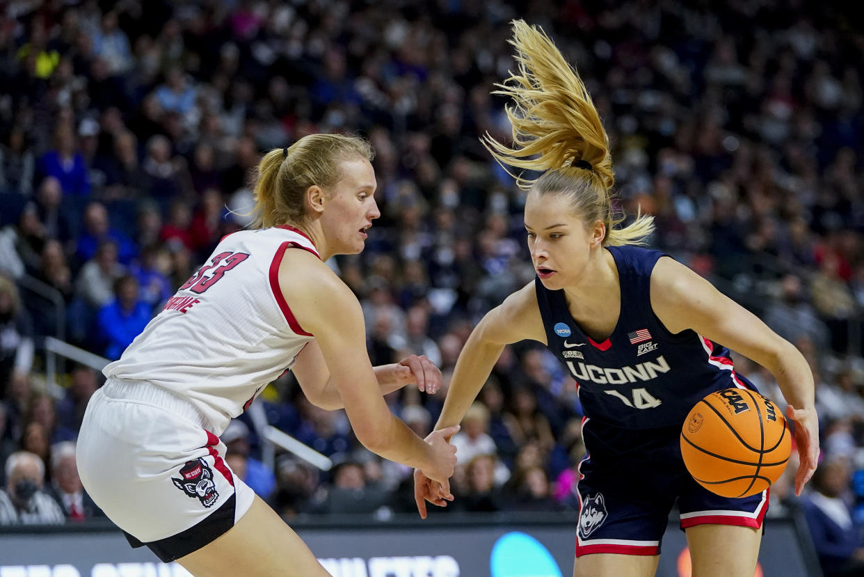 Connecticut forward Dorka Juhasz (14) drives against NC State center Elissa Cunane (33) during the second quarter of the East Regional final college basketball game of the NCAA women's tournament, Monday, March 28, 2022, in Bridgeport, Conn. (AP Photo/Frank Franklin II)