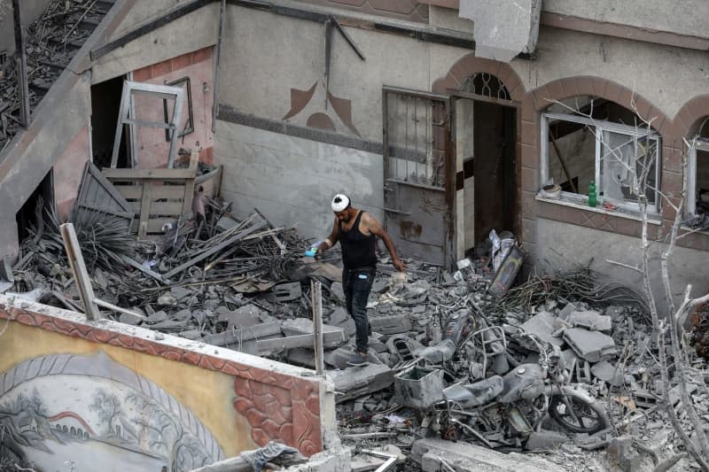 Palestinians inspect damages following an Israeli air strike on Al-Zawayda town in the central Gaza Strip. Omar Naaman/dpa