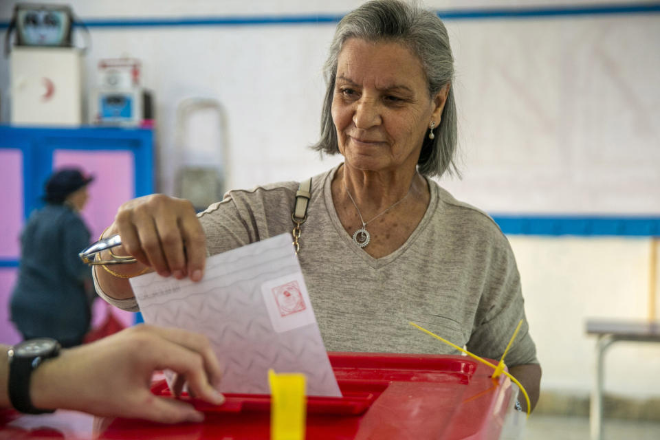 A voter casts her ballot inside a polling station during a parliamentary election in La Marsa, outside Tunis, Tunisia, Sunday, Oct. 6, 2019. Tunisians were electing a new parliament Sunday amid a tumultuous political season, with a moderate Islamist party and a jailed tycoon's populist movement vying to come out on top of a crowded field. (AP Photo/Riadh Dridi)