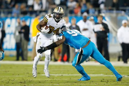 Nov 17, 2016; Charlotte, NC, USA; New Orleans Saints running back Tim Hightower (34) carries the ball as Carolina Panthers defensive end Kony Ealy (94) defends during the fourth quarter at Bank of America Stadium. The Panthers defeated the Saints 23-20. Mandatory Credit: Jeremy Brevard-USA TODAY Sports