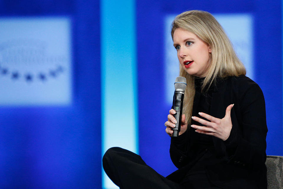 Elizabeth sits with a mic in hand to give a talk