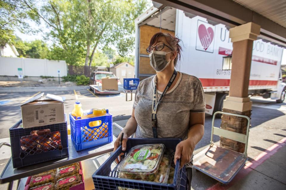 Kimberly Peterson helps to carry food from a delivery truck into the Inn Between.