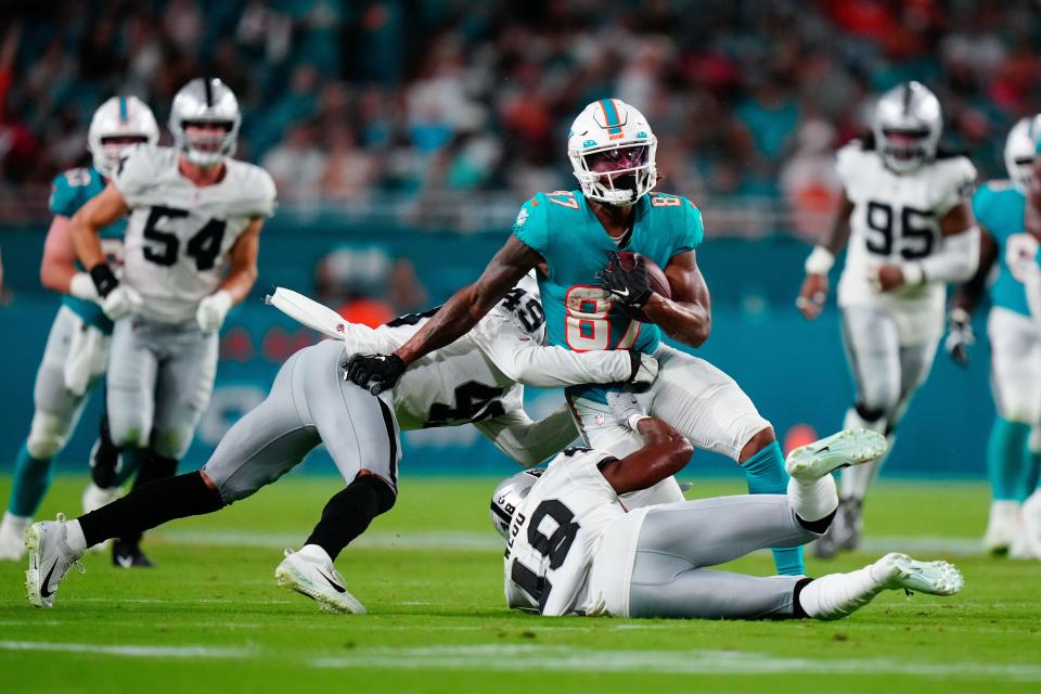 Dolphins receiver Erik Ezukanma played a lot in the preseason, here being tackled by the Raiders' Sam Webb (48) and Matthias Farley (49) after a reception.