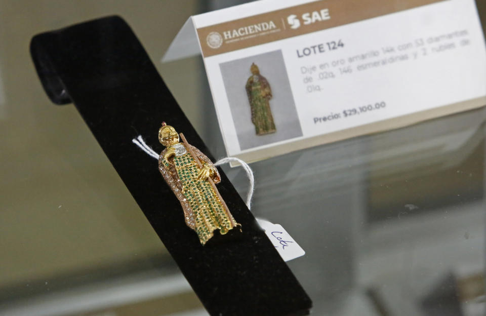 A yellow gold pendant of "San Judas Tadeo" is displayed during an auction of jewelry seized from criminals and tax cheats at Los Pinos Cultural Center, formerly the presidential residence, in Mexico City, Sunday, July 28, 2019. This pendant features 53 diamonds and 146 emeralds, and was not for sale, but strictly on display. (AP Photo/Ginnette Riquelme)