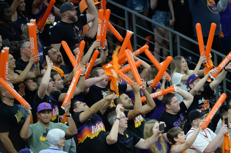 Phoenix Suns fans cheer and smack orange thunder sticks during Game 1 of the NBA Finals. 