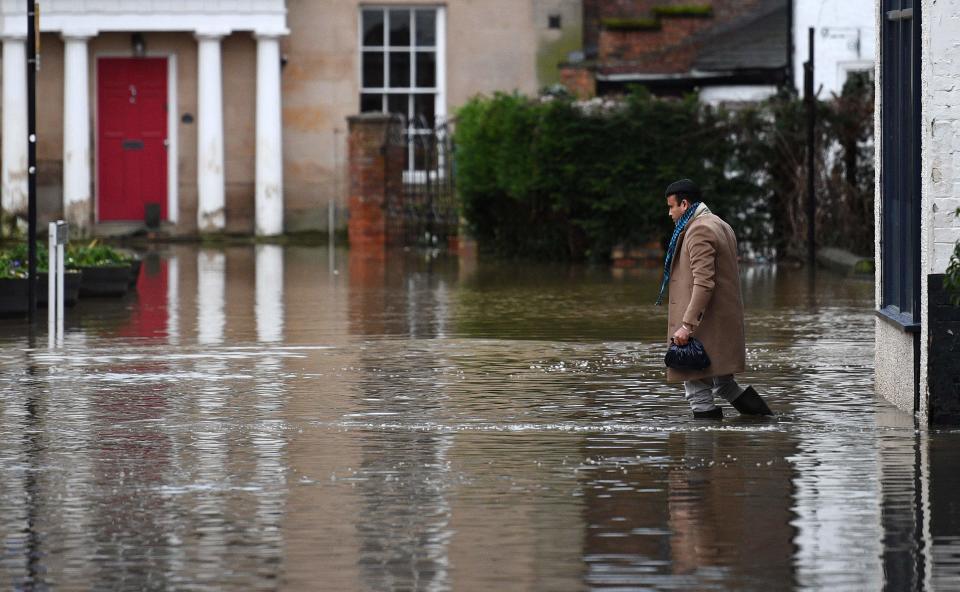A man wades through flood water in Shrewsbury, western England after Storm Christoph brought heavy rains and flooding across the country AFP via Getty Images