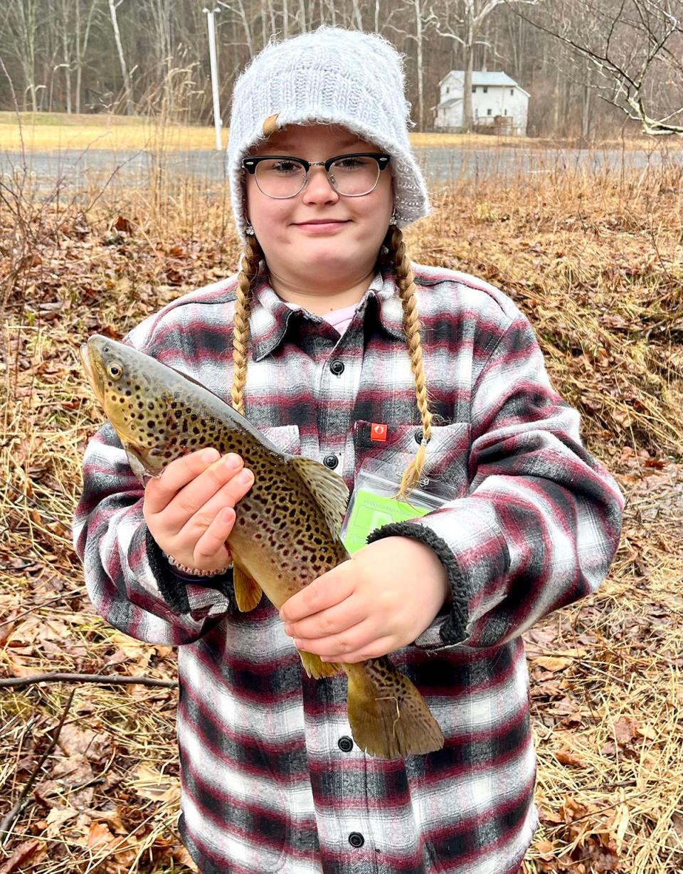 Addison Sislo, a 10-year-old angler who attends Lakeside Elementary, shows off the 17-inch brown trout she caught while fishing with her uncle in the Dyberrry Creek.