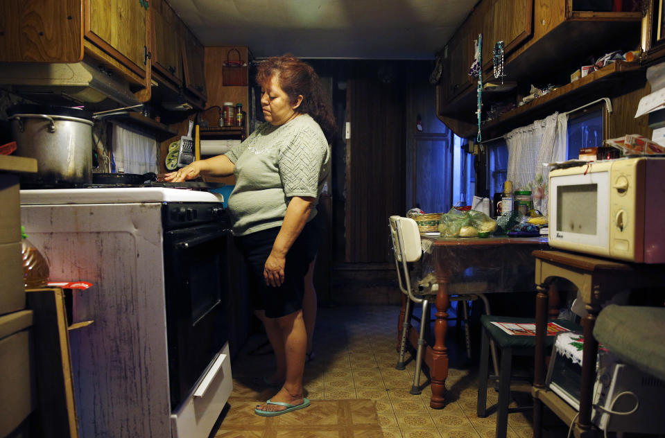 In this Sept. 14, 2015 photo, Dora Martinez cooks food at her home in a trailer park near Fresno, Calif. Residents of the trailer park receive notices warning that their well water contains uranium at a level considered unsafe by federal and state standards.