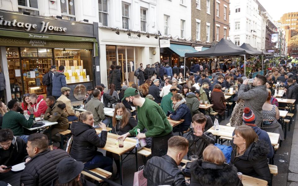 Customers dine in an outdoor seating area for restaurants in Soho in London - Bloomberg