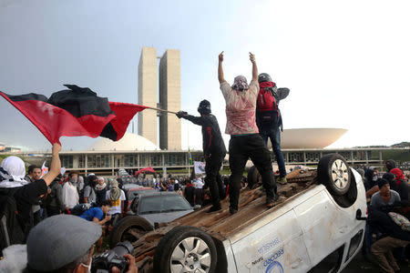 Anti-government demonstrators gesture atop a press car of Tv Record as they attend a demonstration against a constitutional amendment, known as PEC 55, that limits public spending, in front of Brazil's National Congress in Brasilia, Brazil November 29, 2016. REUTERS/Adriano Machado