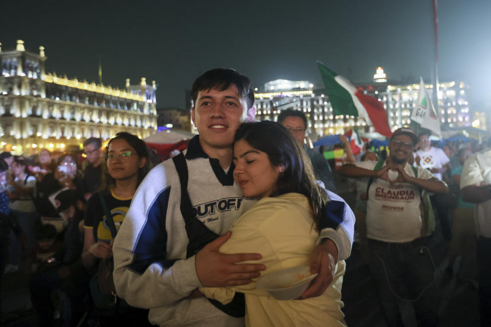 Simpatizantes de la candidata oficialista Claudia Sheinbaum abrazados tras el cierre de urnas en las elecciones generales en el Zócalo, la principal plaza de Ciudad de México, el domingo 2 de junio de 2024. (AP Foto/Ginnette Riquelme)