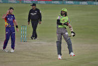 Lahore Qalandars' David Wiese, right, celebrates after playing the winning shot while Karachi Kings Daniel Christian, left, watches during a Pakistan Super League T20 cricket match between Karachi Kings and Lahore Qalandars at the National Stadium, in Karachi, Pakistan, Sunday, Feb. 28, 2021. (AP Photo/Fareed Khan)