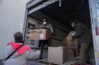 Pastor Torrey Barrett, center, gets help from migrants to unload supplies at the KLEO Community Family Life Center Wednesday, Nov. 29, 2023, in Chicago. The community center and church welcomed about 40 migrants who were previously living at police stations and airports. (AP Photo/Erin Hooley)