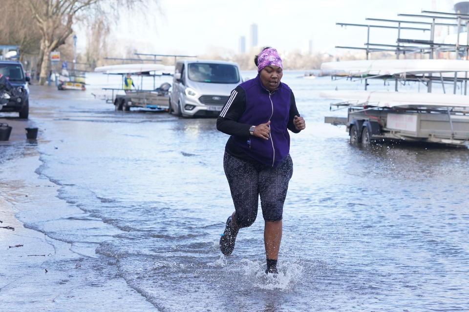 A jogger goes through flood water by the river Thames at Putney, London after Storm Dudley hit on Thursday night. Picture date: Thursday February 17, 2022.