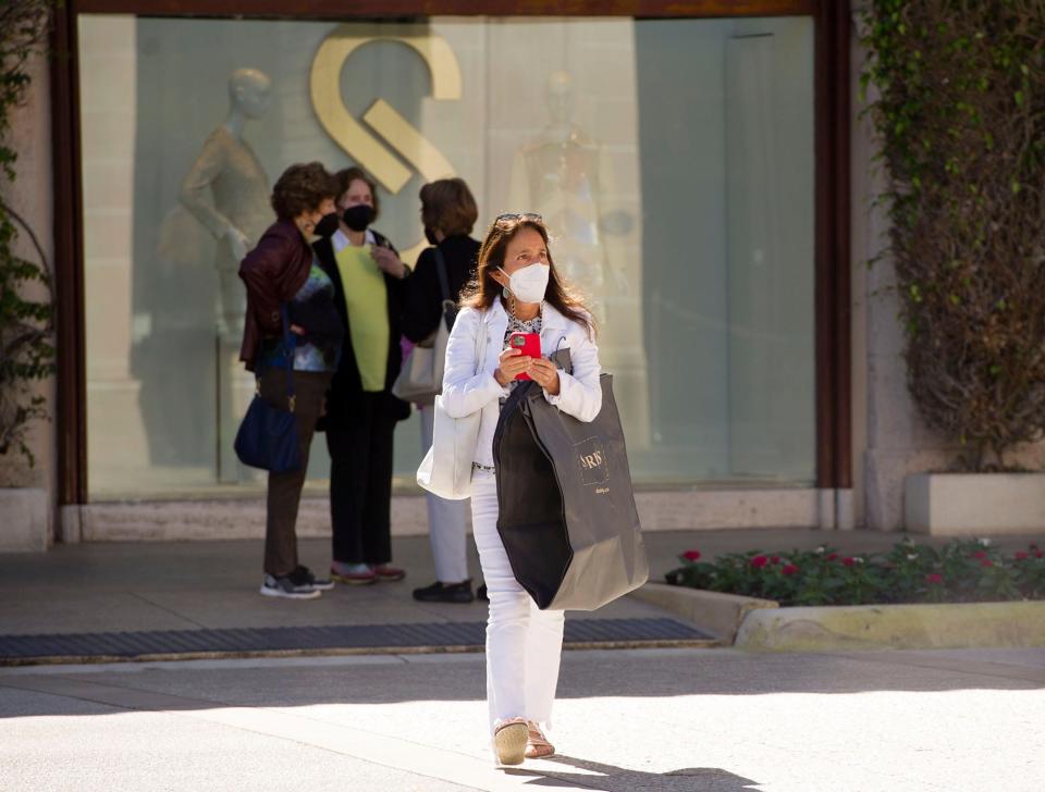 Worth Avenue shoppers wear masks between stores in January during the spike in COVID-19 cases fueled by the omicron variant.