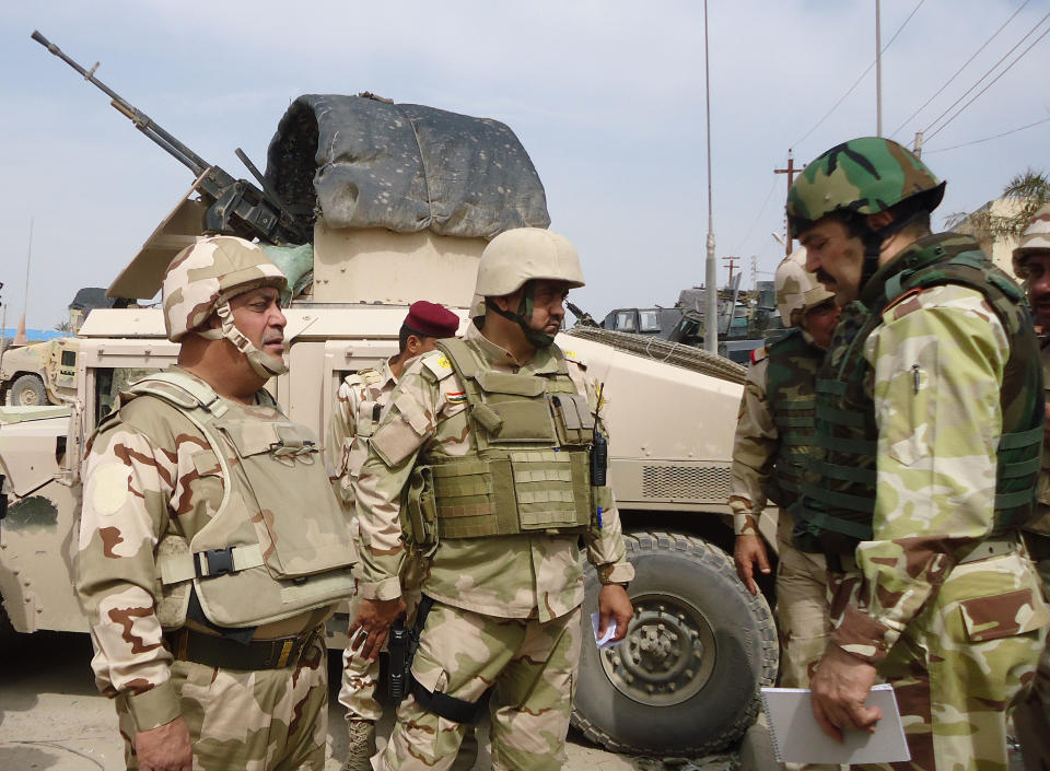 In this photo released by the Iraqi Army taken on March 20, 2014, the commander of Anbar Operations, Lt. Gen. Rasheed Fleih, right, speaks with officers before attacking al-Qaida positions in Ramadi, 70 miles (115 kilometers) west of Baghdad, Iraq. Iraqi military officials are warning that efforts to clear militants from Fallujah and parts of nearby Ramadi are proving much more difficult than they anticipated when the jihadists showed up three months ago. That realization, as they acknowledged during a recent tour of special forces operations, casts doubt on Iraq's ability to hold elections in Fallujah next month. (AP Photo/HO)