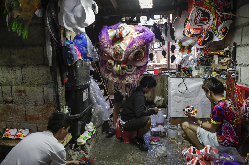 Friends and relatives work on finishing Lion and Dragon projects as their group seek other ways to earn a living at a creekside slum at Manila's Chinatown, Binondo, Philippines on Feb. 3, 2021. The Dragon and Lion dancers won't be performing this year after the Manila city government banned the dragon dance, street parties, stage shows or any other similar activities during celebrations for Chinese New Year due to COVID-19 restrictions leaving several businesses without income as the country grapples to start vaccination this month. (AP Photo/Aaron Favila)