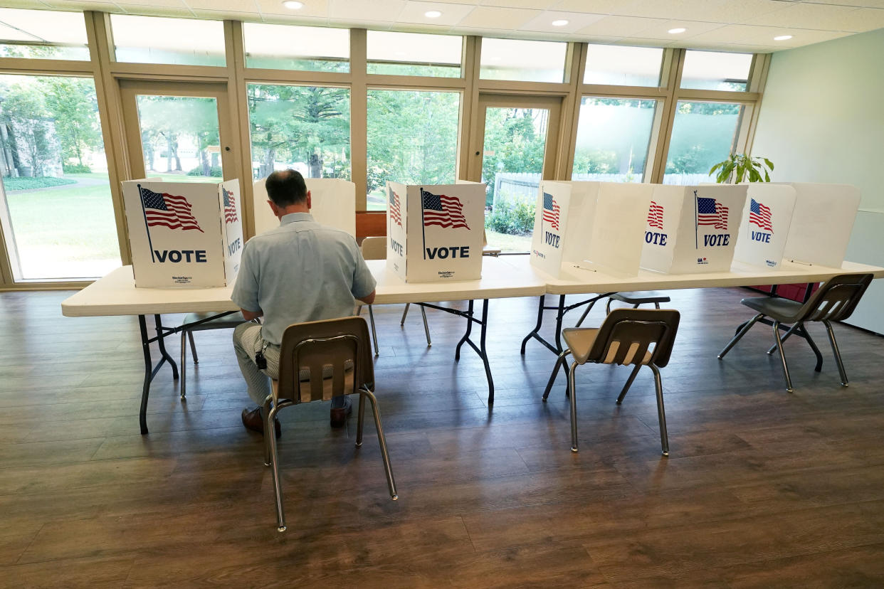 A voter sits alone at a poll kiosk to cast his vote at a Mississippi Second Congressional District Primary election precinct, June 7, 2022, in Jackson, Miss. (AP)