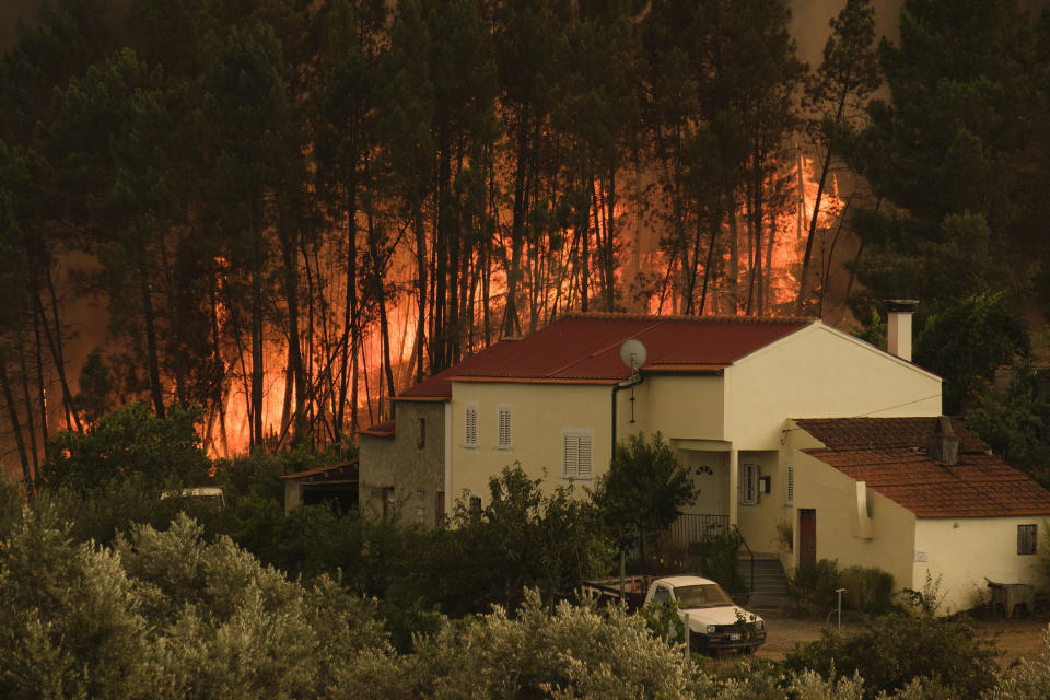 The fire advance at the village of Chaveira, near Macao, in central Portugal on Monday, July 22, 2019. More than 1,000 firefighters are battling a major wildfire amid scorching temperatures in Portugal, where forest blazes wreak destruction every summer. About 90% of the fire area in the Castelo Branco district, 200 kilometers (about 125 miles) northeast of the capital Lisbon, has been brought under control during cooler overnight temperatures, according to a local Civil Protection Agency commander. (AP Photo/Sergio Azenha)
