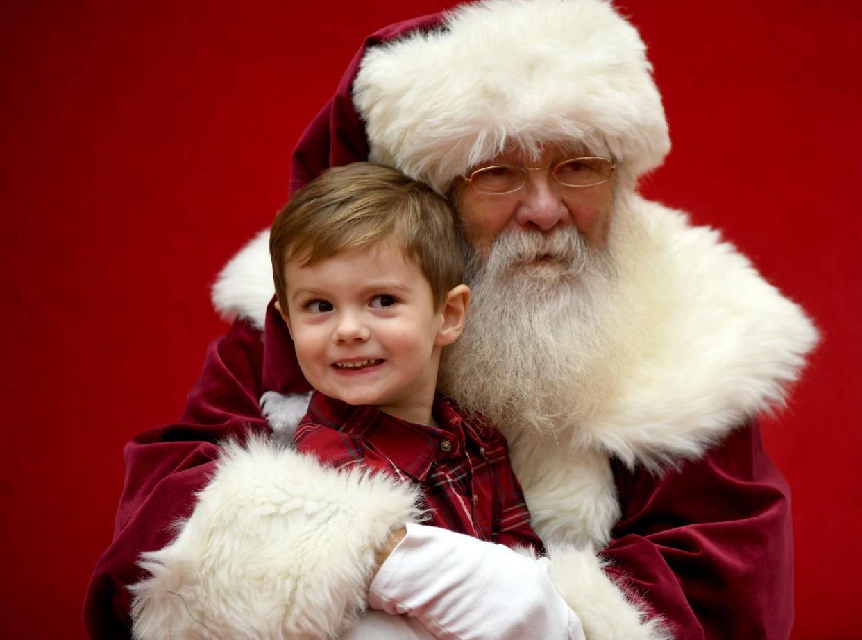 Giovanni Campitelli, 3, of North Canton strikes a pose during a visit to see Santa, with help from Bernie Roberts of Akron, at Belden Village Mall.