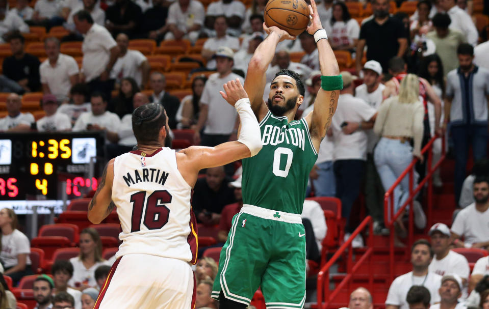 Boston Celtics&#39; Jayson Tatum hits a shot over the Miami Heat&#39;s Caleb Martin in Game 4 of the Eastern Conference finals on May 23, 2023, in Miami. (Jim Davis/The Boston Globe via Getty Images)