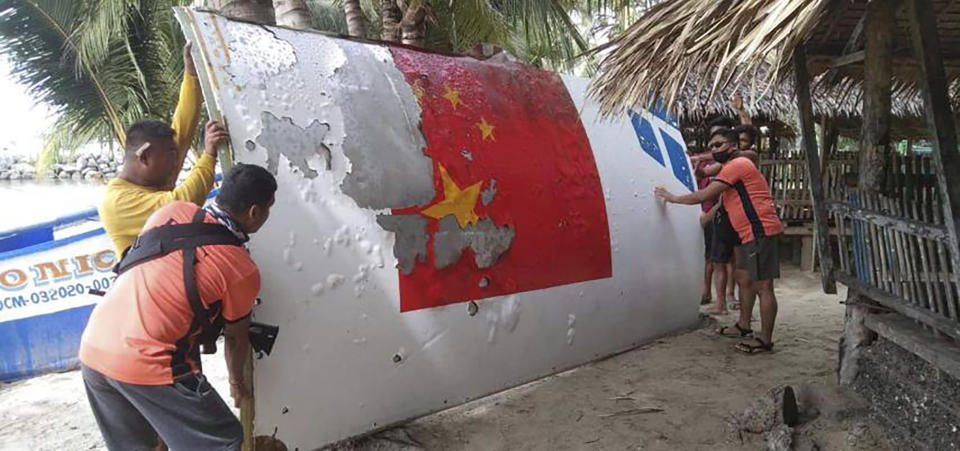 In this handout photo provided by the Philippine Coast Guard, Coast Guard personnel carry debris, which the Philippine Space Agency said has markings of the Long March 5B (CZ-5B) Chinese rocket that was launched on July 24, after it was found in waters off Mamburao, Occidental Mindoro province, Philippines on Aug. 2022. In July, the core stage debris of the Long March 5B rocket that was launched in China landed in Philippine waters in an uncontrolled reentry, the agency said. No damage or injuries were reported. (Philippine Coast Guard via AP)