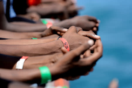 FILE PHOTO: Hands of migrants are seen on board the MV Aquarius in the harbour of Valletta, Malta, August 15, 2018. REUTERS/Guglielmo Mangiapane/File Photo