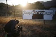 A television cameraman films a sympathy sign at sunrise outside Umpqua Community College in Roseburg, Oregon, United States, October 2, 2015. REUTERS/Lucy Nicholson