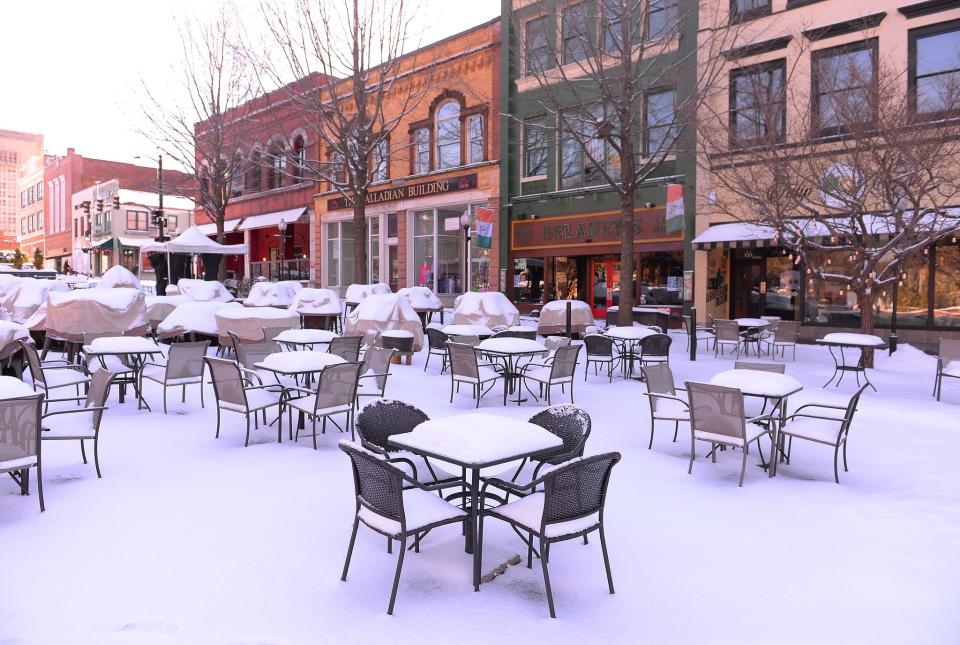 Snow covers tables along Main Street on Morgan Square in downtown Spartanburg Monday morning, January 17, 2022. 